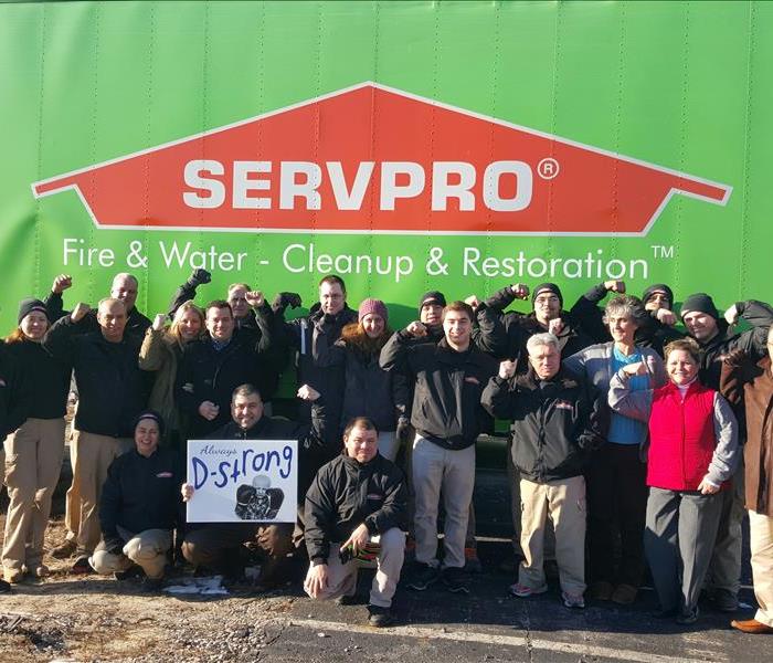 employees standing in front of a SERVPRO Truck