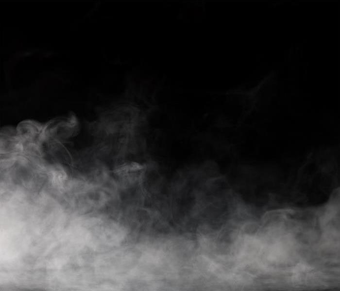 Smoke rising over a black background