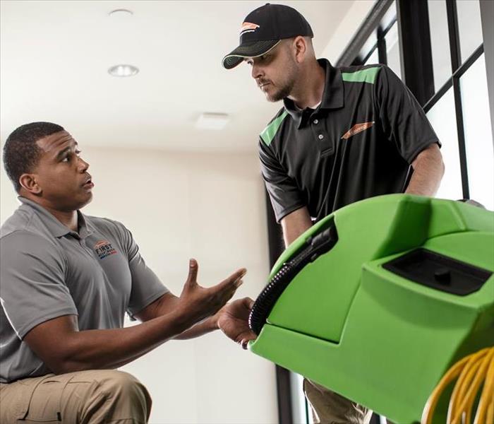 SERVPRO employees face each other talking.