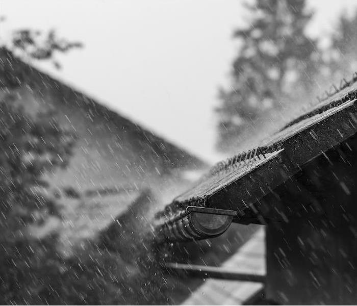 a heavy rain pouring down on roof and gutters